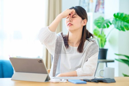 Photo for A woman feels stressed while operating a computer in her room - Royalty Free Image
