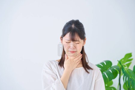 Photo for A young woman feels discomfort in her throat  indoors - Royalty Free Image