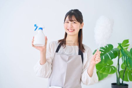 Photo for Young woman with cleaning tools indoors - Royalty Free Image