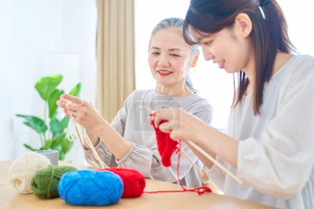 Photo for Senior woman and young woman knitting in the room - Royalty Free Image
