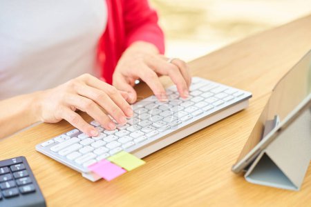 Foto de Manos de una mujer escribiendo en un teclado de computadora en el interior - Imagen libre de derechos