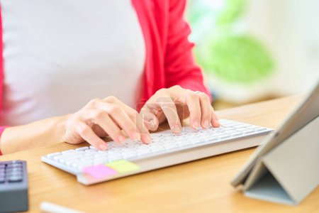 Photo for Hands of a woman typing on a computer keyboard indoors - Royalty Free Image