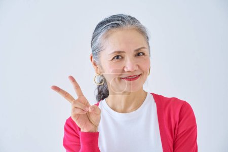 Photo for Senior woman doing peace sign in the room - Royalty Free Image