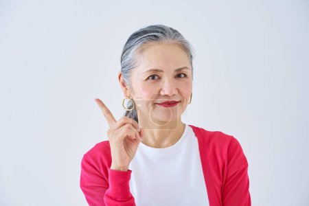 Photo for Senior woman posing with her index finger raised indoors - Royalty Free Image