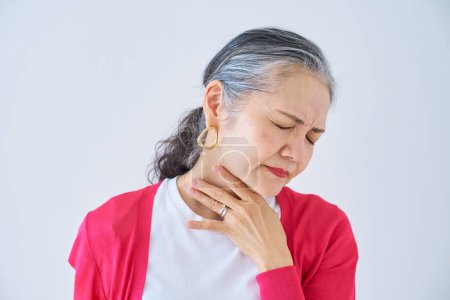 Photo for A senior woman feels discomfort in her throat indoors - Royalty Free Image