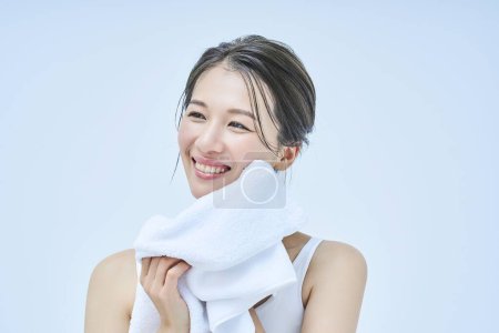 Téléchargez les photos : Femme essuyant son visage avec une serviette - en image libre de droit