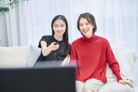 Foto de Dos mujeres viendo la televisión en la habitación - Imagen libre de derechos