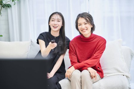 Foto de Dos mujeres viendo la televisión en la habitación - Imagen libre de derechos