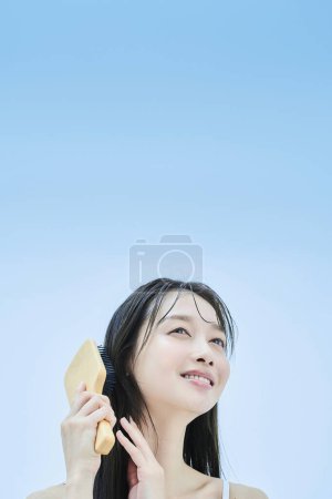 long-haired woman brushing her hair with smile