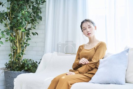 Photo for Smiling young woman wearing loungewear relaxing in her room - Royalty Free Image