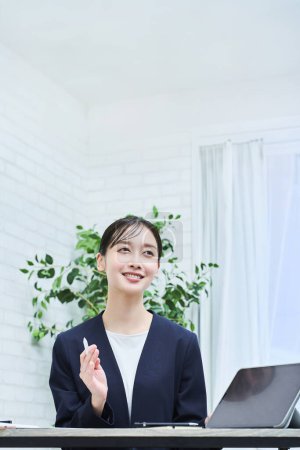 Foto de Una mujer en traje hablando con una sonrisa en la oficina - Imagen libre de derechos