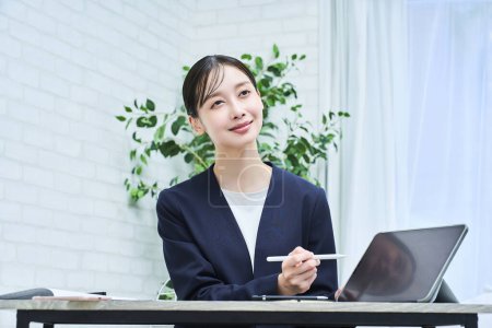 Téléchargez les photos : Une femme en costume parlant avec un sourire au bureau - en image libre de droit