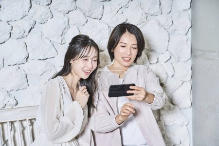 Photo for Two women looking at a smartphone screen - Royalty Free Image
