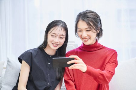 Foto de Dos mujeres mirando la pantalla de un smartphone - Imagen libre de derechos