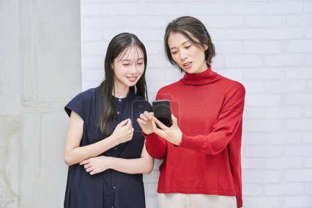 Téléchargez les photos : Deux femmes regardant l'écran du smartphone - en image libre de droit