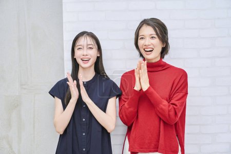 Téléchargez les photos : Deux femmes souriantes et applaudissant joyeusement - en image libre de droit