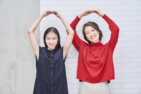 Téléchargez les photos : Deux femmes souriant et donnant un signe OK main - en image libre de droit