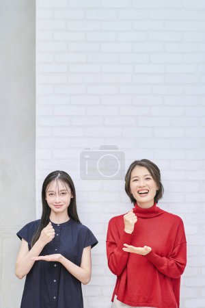 Photo for Two women smiling and posing convincingly indoors - Royalty Free Image