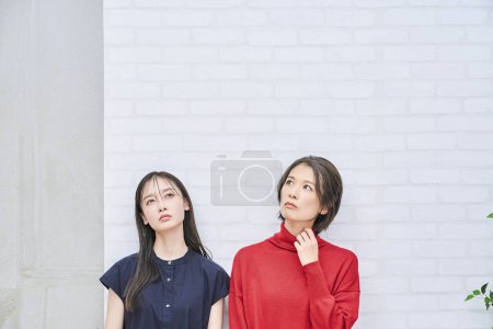Photo for Two Japanese women looking up indoors - Royalty Free Image