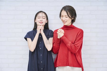 Photo for Two Japanese women pose in prayer - Royalty Free Image