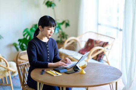 Foto de Mujer joven que utiliza la tableta PC en una habitación informal - Imagen libre de derechos