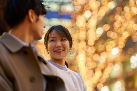 Foto de Una mujer felizmente hablando con un hombre en un paisaje urbano iluminado - Imagen libre de derechos