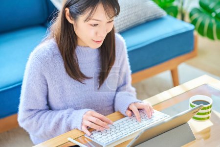 Téléchargez les photos : Une femme travaillant sur un ordinateur dans une pièce décontractée - en image libre de droit