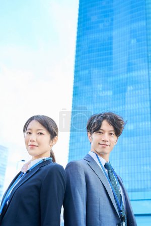 Photo for Man and woman in suits standing side by side - Royalty Free Image