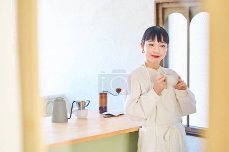 Foto de Mujer joven con taza de café en la cocina - Imagen libre de derechos