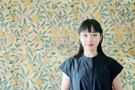 Téléchargez les photos : Portrait de jeune femme et mur de fond floral - en image libre de droit