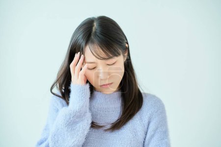 Mujer joven que sufre de dolor de cabeza en el interior