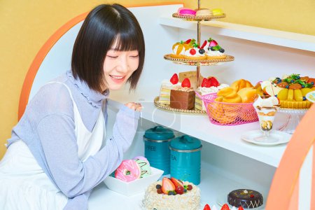 Eine junge Frau umringt von Süßigkeiten im Zimmer