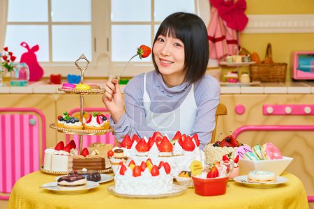 Téléchargez les photos : Une jeune femme mangeant des fraises dans la chambre - en image libre de droit