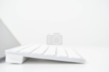 Foto de Primer plano del teclado inalámbrico desde un lado en una mesa blanca - Imagen libre de derechos