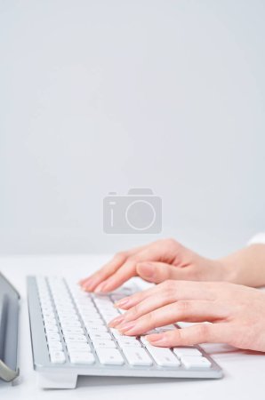 Hands of a woman typing on a keyboard