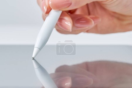 Mano de una mujer operando una pluma de lápiz óptico