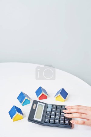 Colorful house models and calculator on the talbe