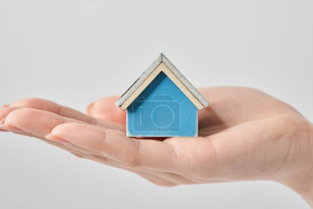 Foto de Una modelo de casa sostenida en la palma de la mano de una mujer y fondo blanco - Imagen libre de derechos