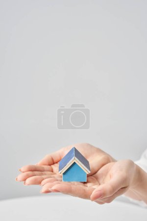 Photo for A house model held in the palm of a woman's hand and white background - Royalty Free Image