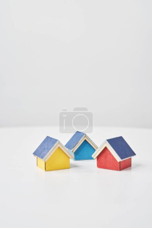Téléchargez les photos : Modèles de maisons multiples alignées sur une table blanche - en image libre de droit
