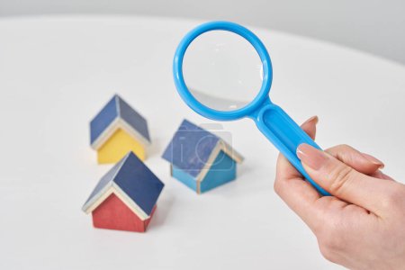 Photo for Magnifying glass pointed at a house model on the table - Royalty Free Image