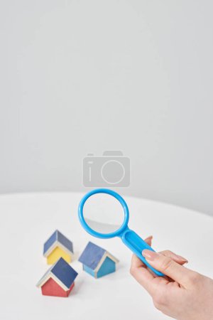 Magnifying glass pointed at a house model on the table