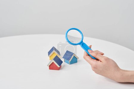 Magnifying glass pointed at a house model on the table