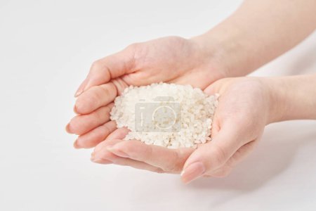 Téléchargez les photos : Une tasse de riz à la main et fond blanc - en image libre de droit