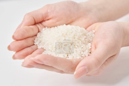 Eine Tasse Reis in der Hand und weißer Hintergrund