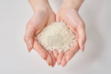 A cup of rice in the hand and white background