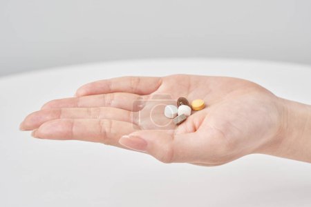 Photo for Various pills on the hand and white background - Royalty Free Image