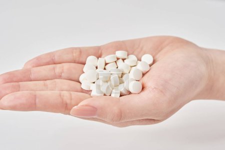 many pills in the palm and white background