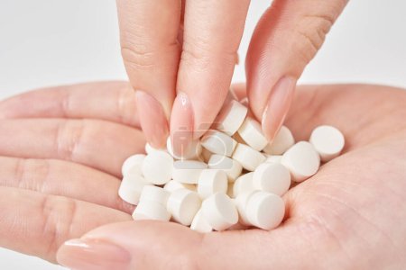 many pills in the palm and white background