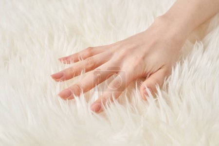 A woman's hand touches the fluffy fabric